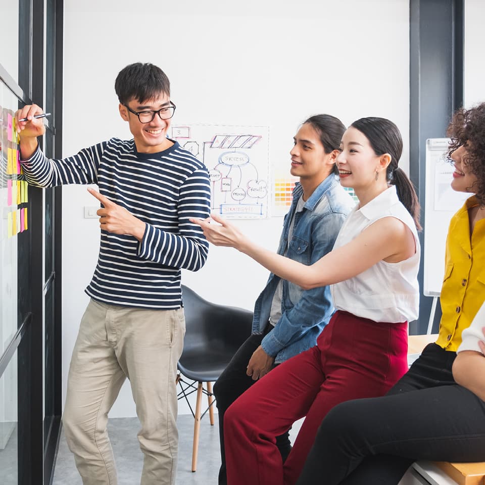 Coworkers pointing at whiteboard