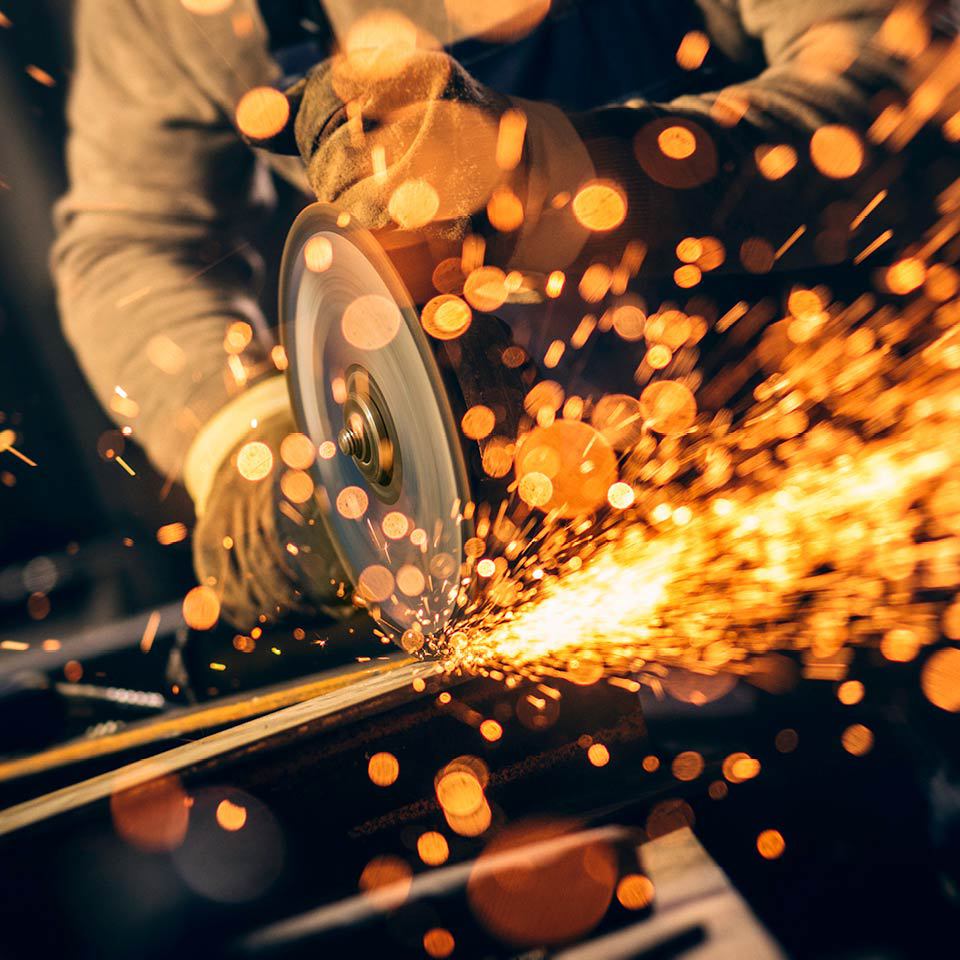 man operating a power saw with sparks flying